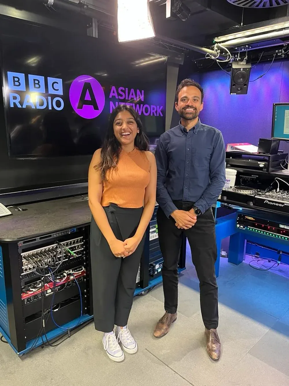 Shiv Haria standing with presenter Sonya Barlow in the BBC Radio Asian Network studio, where he was interviewed about property investment